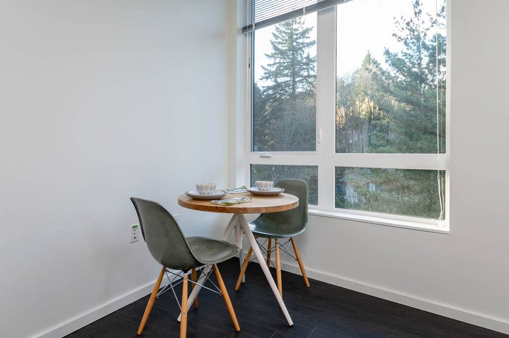 a small table with two chairs in front of a window