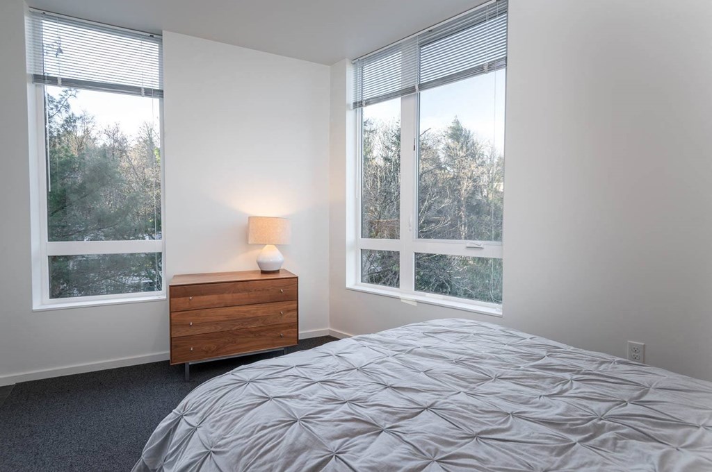 a bedroom with a bed and three windows