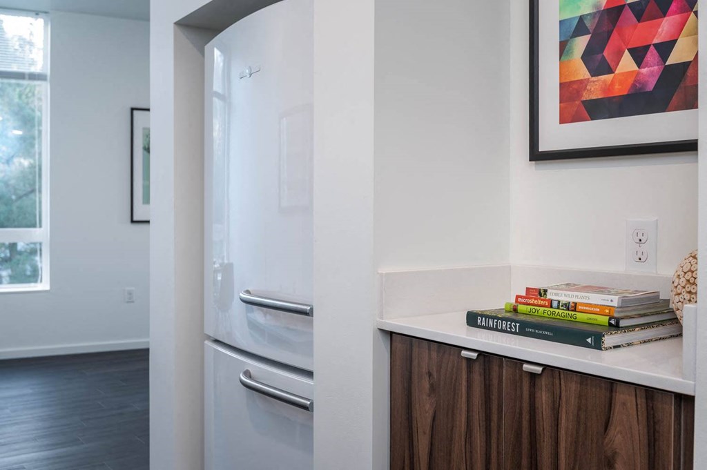 a kitchen with a refrigerator and a counter with books