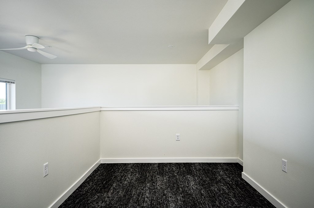 loft room with half wall, dark hardwood floor and white walls