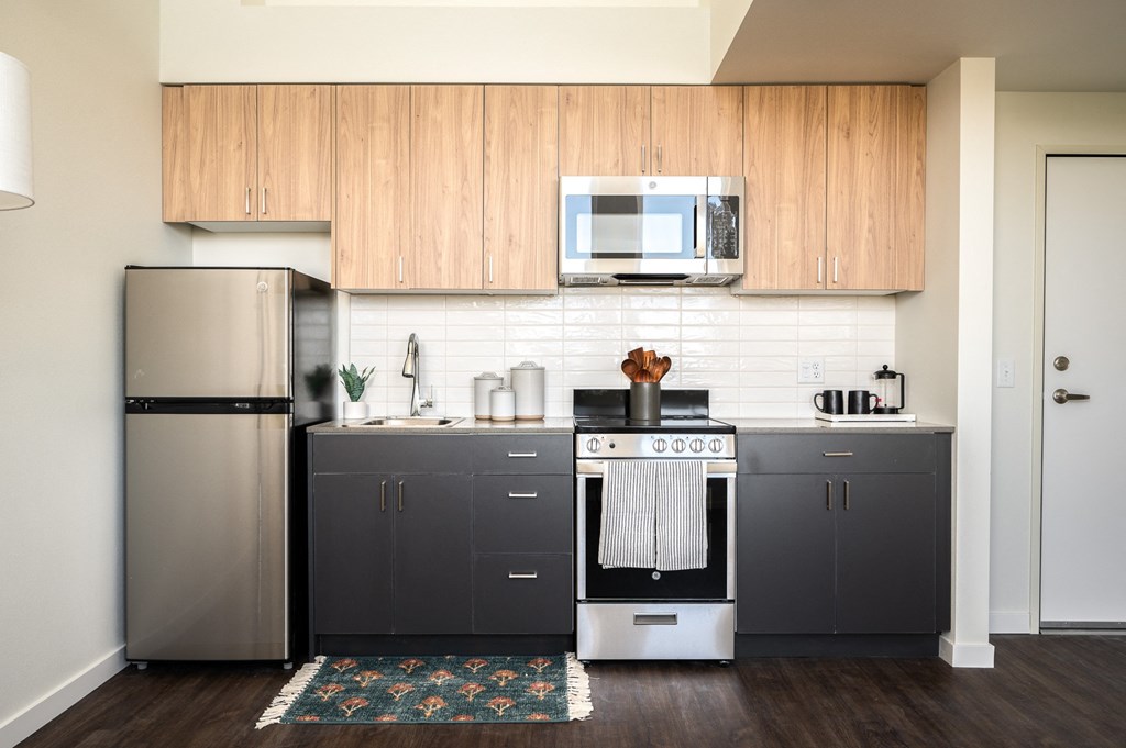 a kitchen with stainless steel appliances and two-tone wooden cabinets