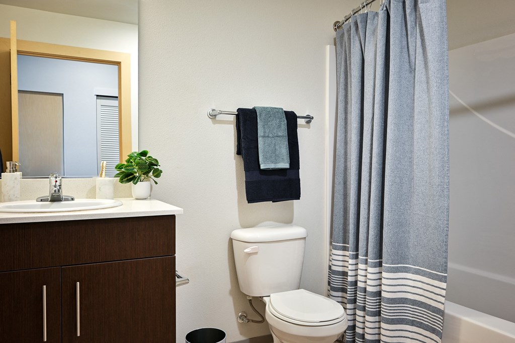 studio bathroom with a toilet and a shower and a sink