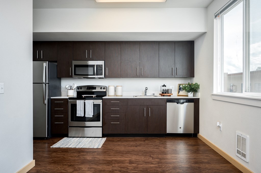 The Waterline Everett, WA Kitchen Studio with dark cabinets and stainless steel appliances