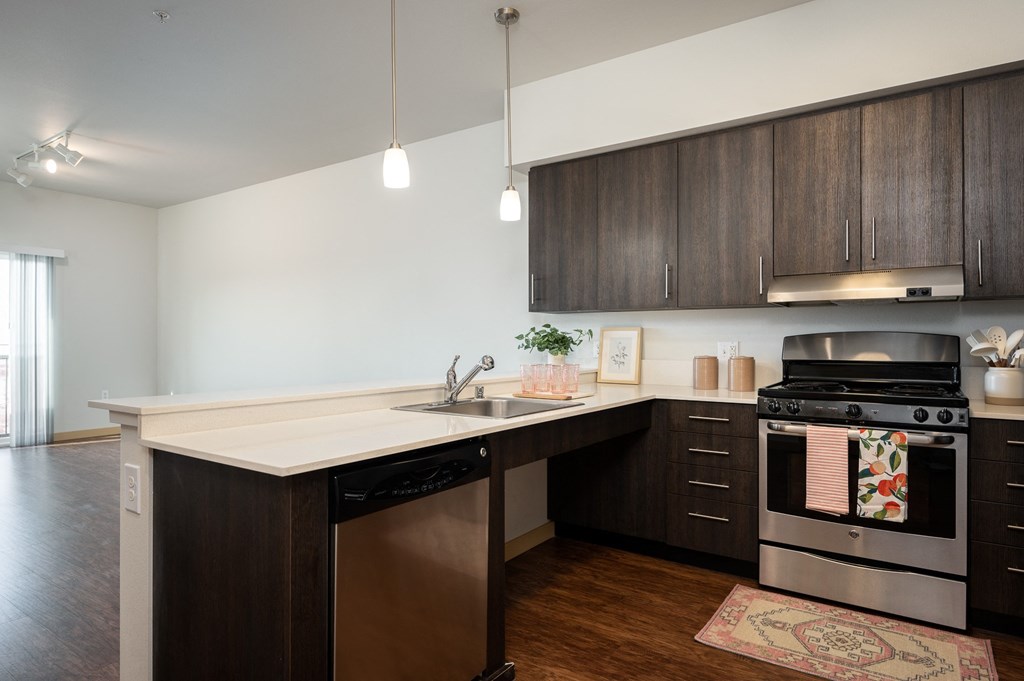 a kitchen with dark wood cabinets and a white counter top