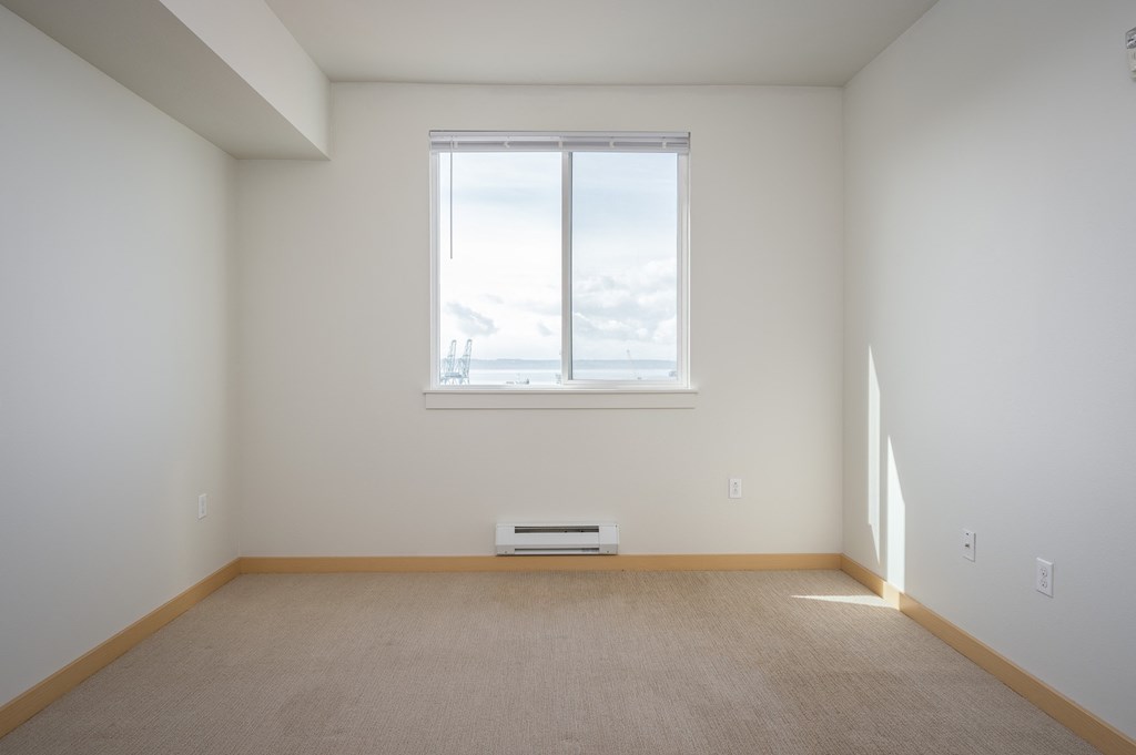bedroom with a large window and carpet