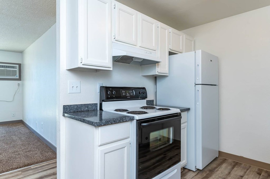 A kitchen with white cabinets and a black stove top oven.