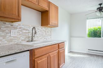 an empty kitchen with wooden cabinets and a sink