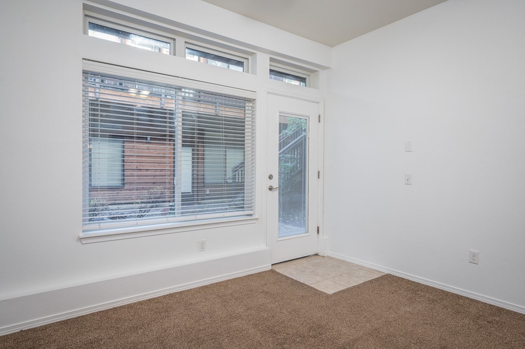 an empty room with a large window and a door