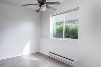an empty room with a ceiling fan and a window