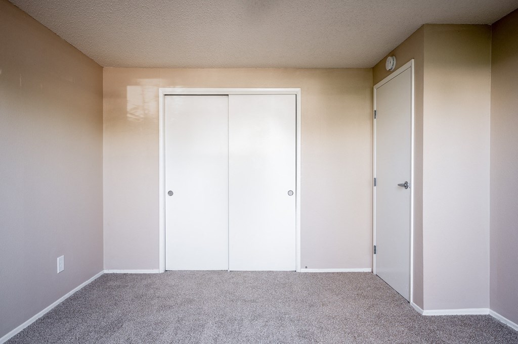 an empty room with white doors and a carpeted floor