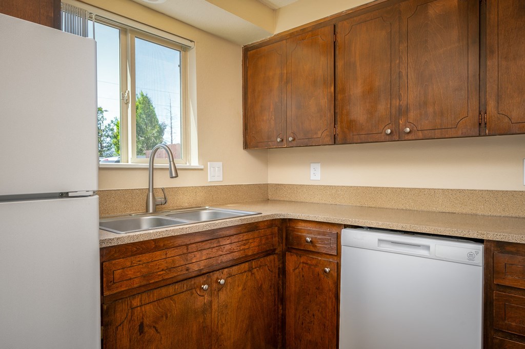 a kitchen with wooden cabinets and a sink and a dishwasher