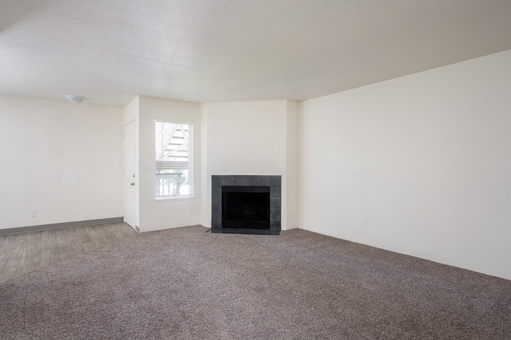 a living room with white walls and a black fireplace