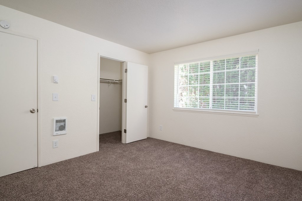 a bedroom with carpet and a large window