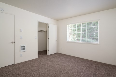 a bedroom with carpet and a door to a closet