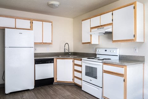 an empty kitchen with white appliances and wooden cabinets