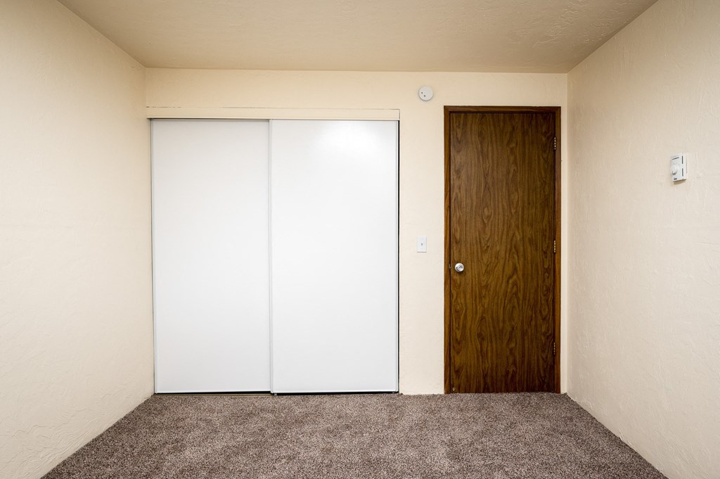 an empty room with a closet and a door