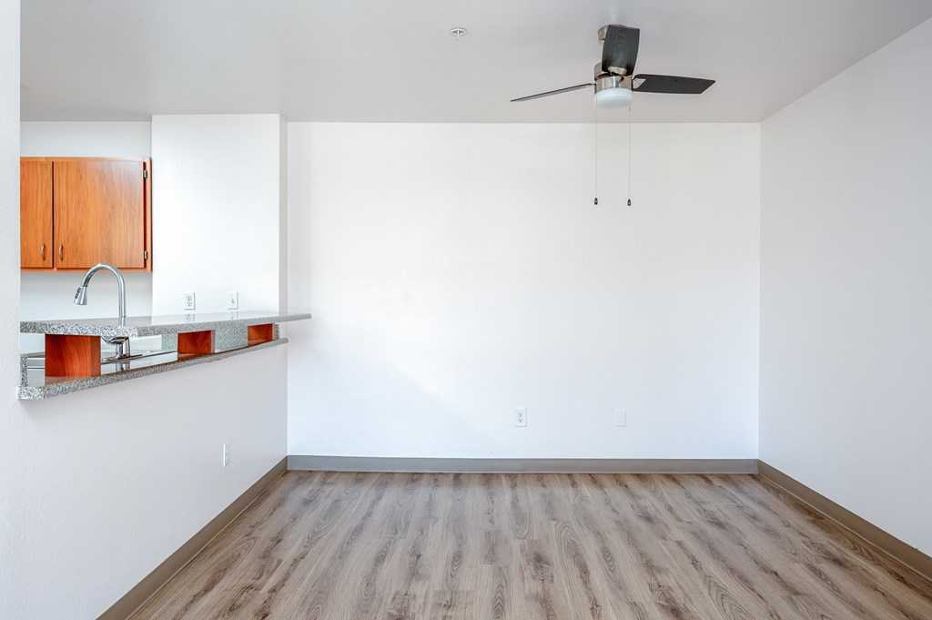Empty room with wooden floor and ceiling fan.