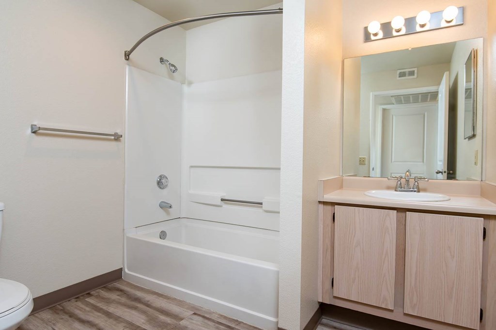 A white bathroom with a walk-in shower and a sink.