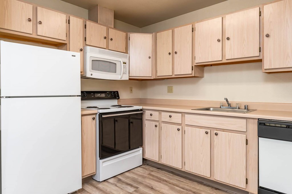 A kitchen with wooden cabinets and white appliances.