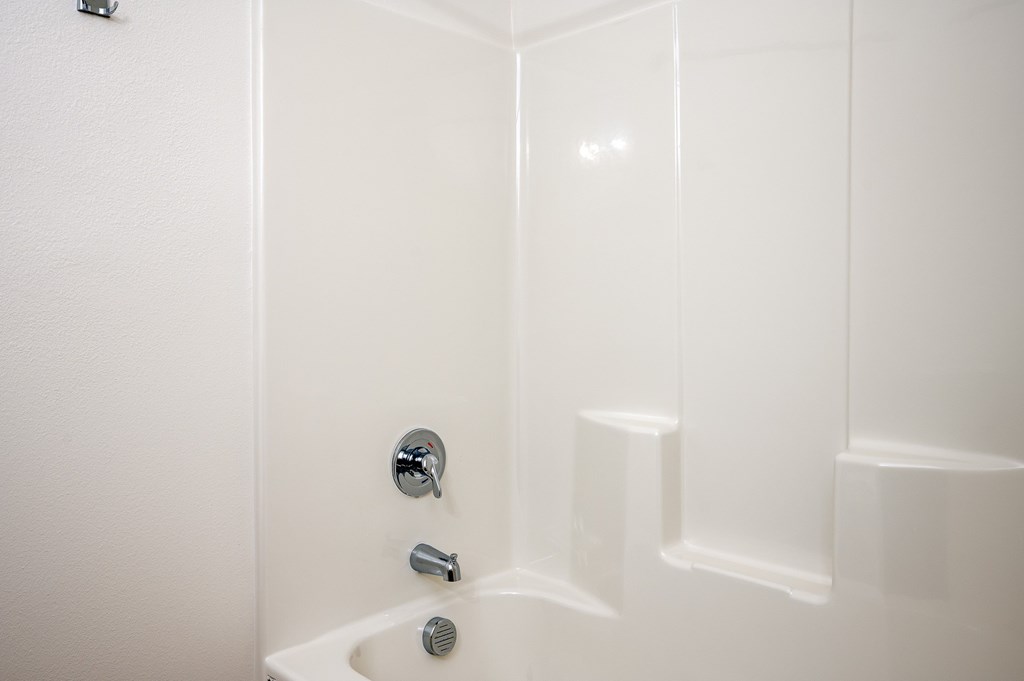 A white bathroom with a tub and shower.