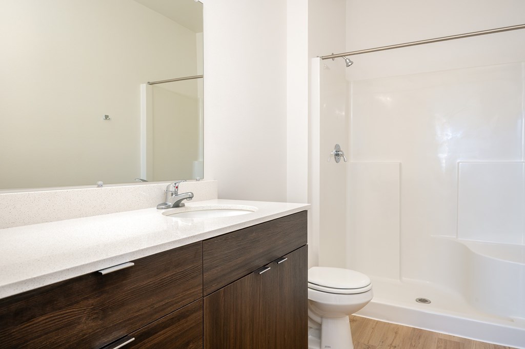 A white sink with a silver faucet and a white toilet in a bathroom.