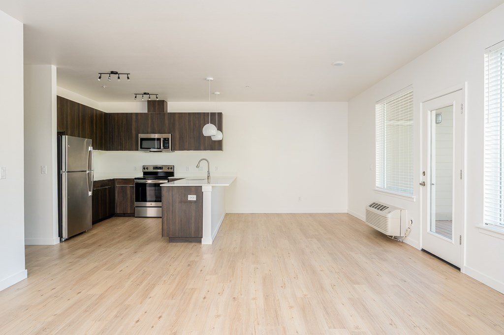 A kitchen with wooden floors and white walls.