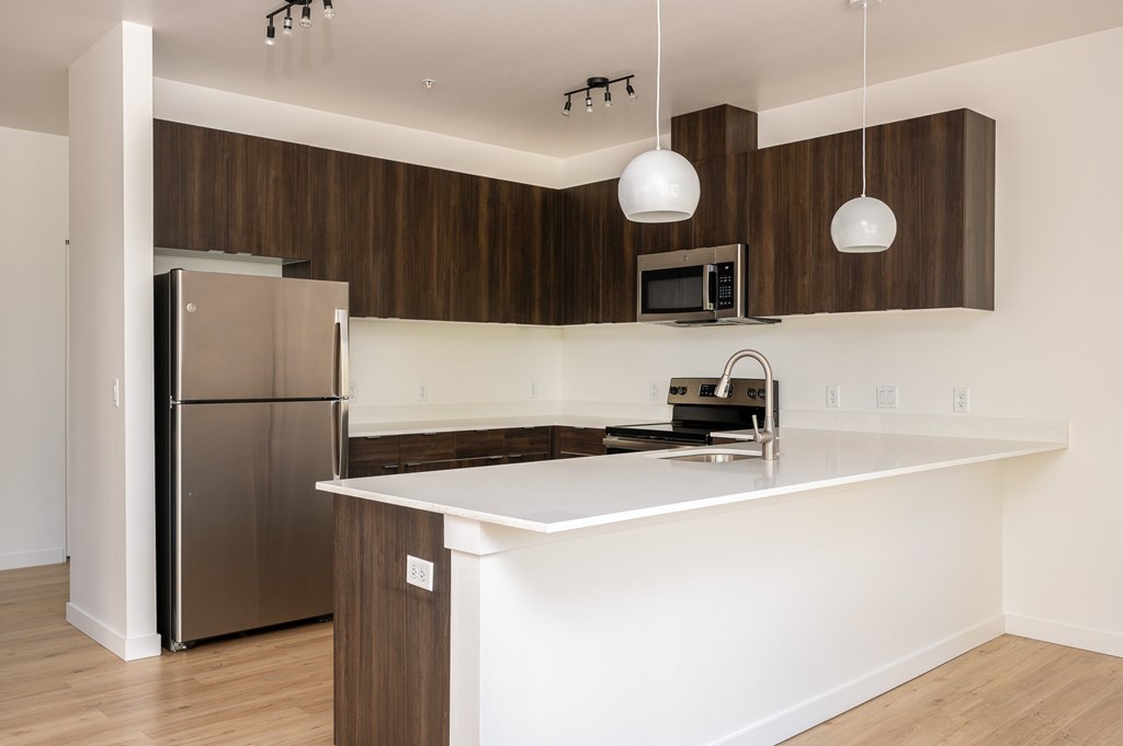 A modern kitchen with a refrigerator, microwave, and a countertop.