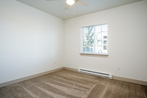 A room with a carpeted floor and a window.