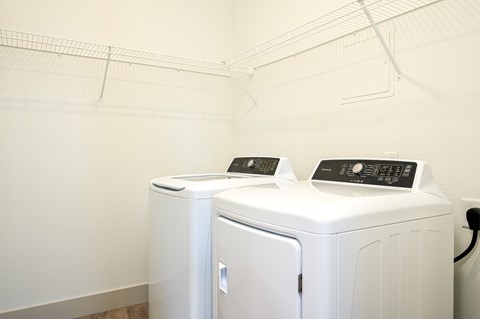 Two white washing machines in a laundry room.