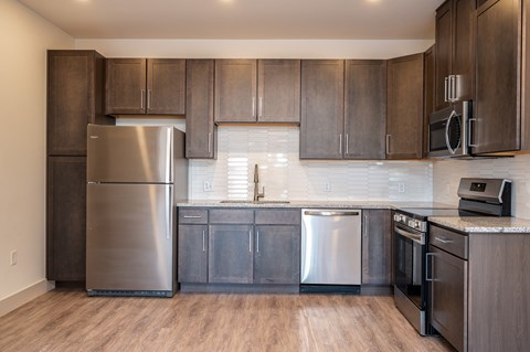 A kitchen with a stainless steel refrigerator and oven.