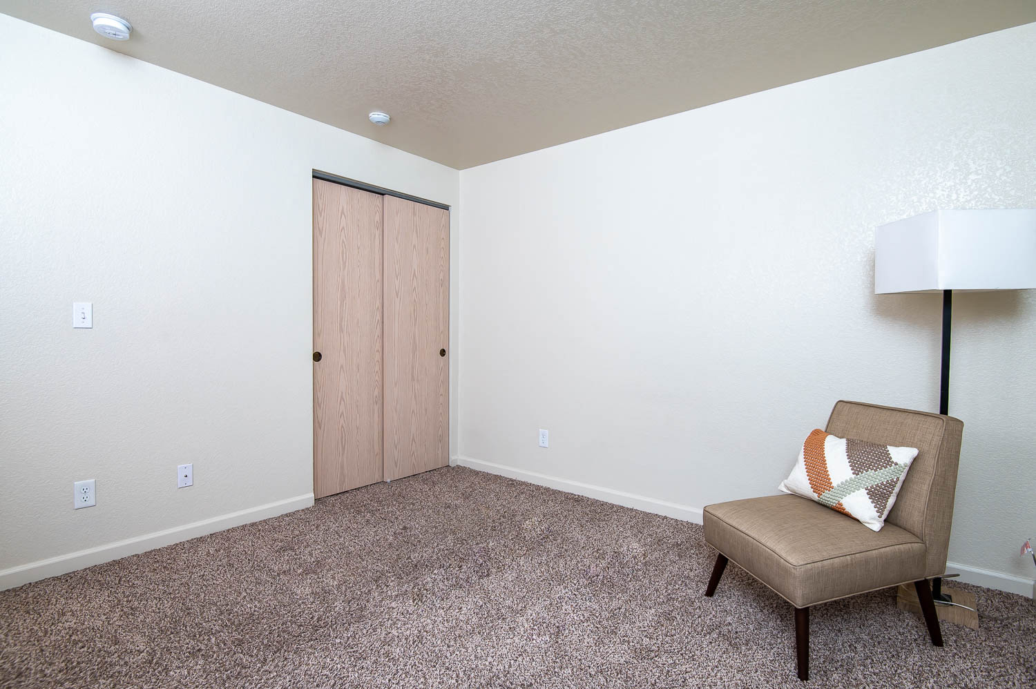 a living room with a chair and a closet
