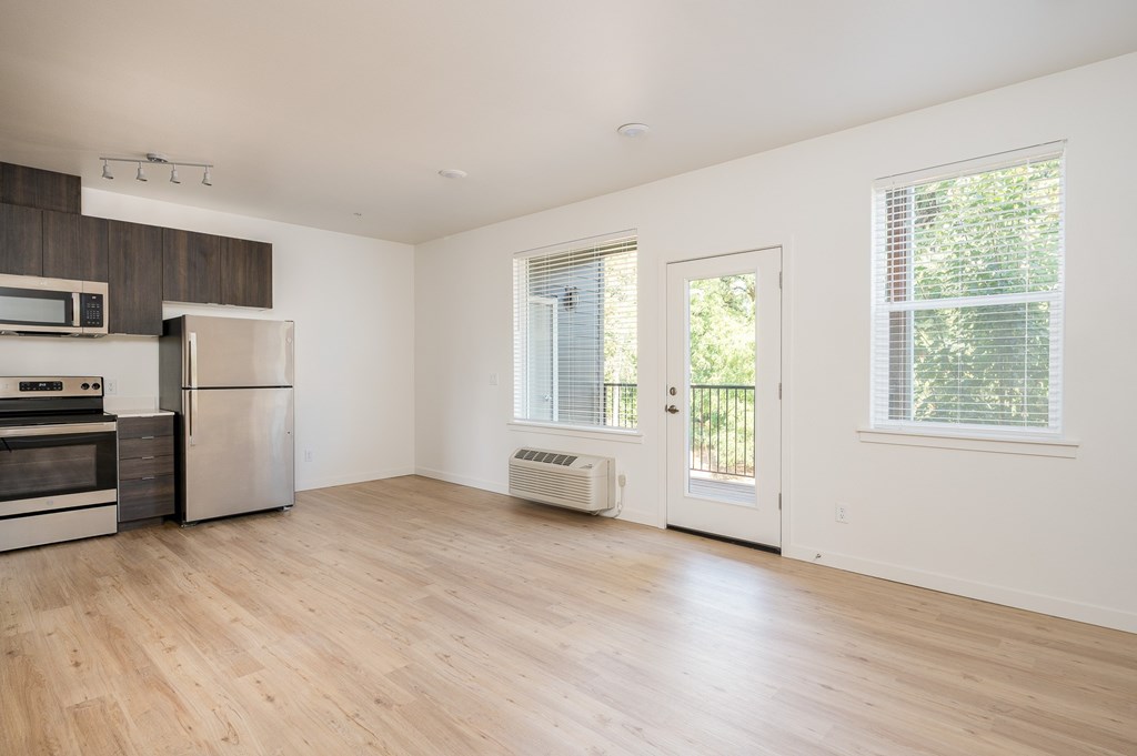 A kitchen with a refrigerator, oven, and microwave.
