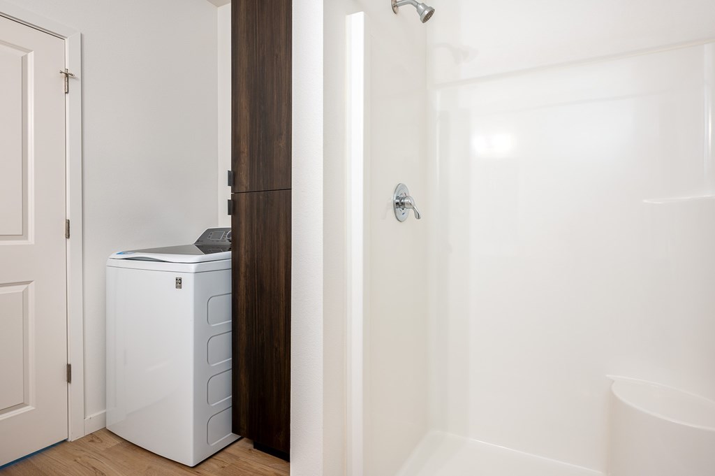 A white washing machine is in a small room.