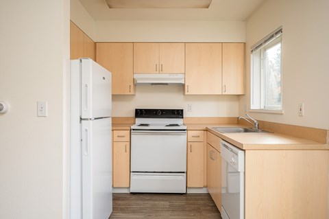 A kitchen with wooden cabinets and white appliances.