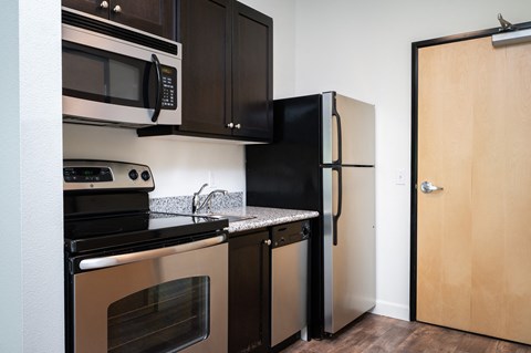 a kitchen with stainless steel appliances and a black refrigerator