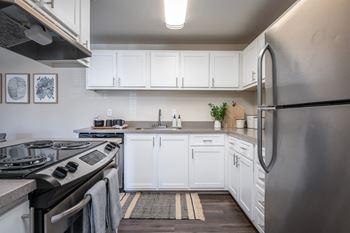 a kitchen with white cabinets and stainless steel appliances