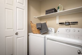 a laundry room with a washer and dryer and a door to the bathroom