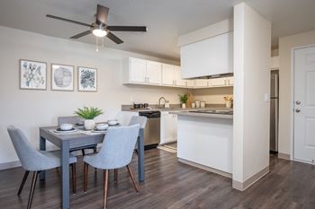 a dining room and kitchen with a ceiling fan and a table and chairs