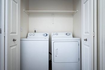 a white washer and dryer in a white laundry room