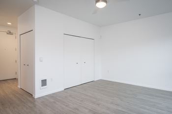 an empty room with white walls and a wood floor
