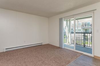an empty living room with sliding glass doors and carpet