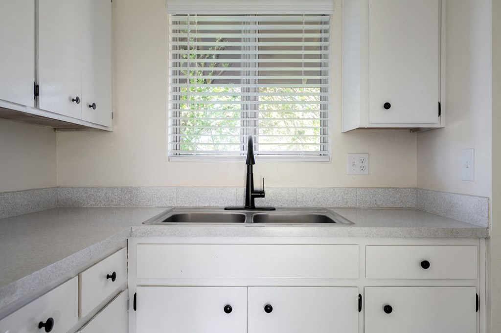 a kitchen with white cabinets and a sink