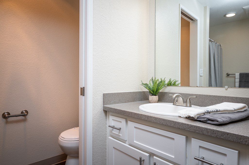 Sundial | Three Bedroom Primary Bathroom with White Cabinetry and Large Mirror