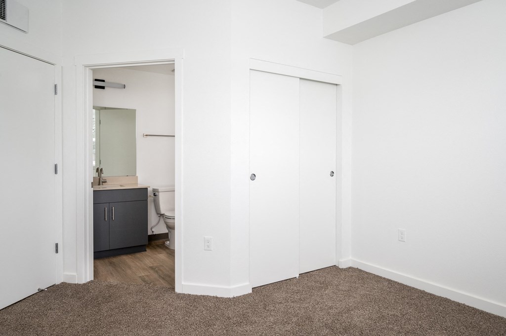 A white door is open to a bathroom with a sink and a cabinet.