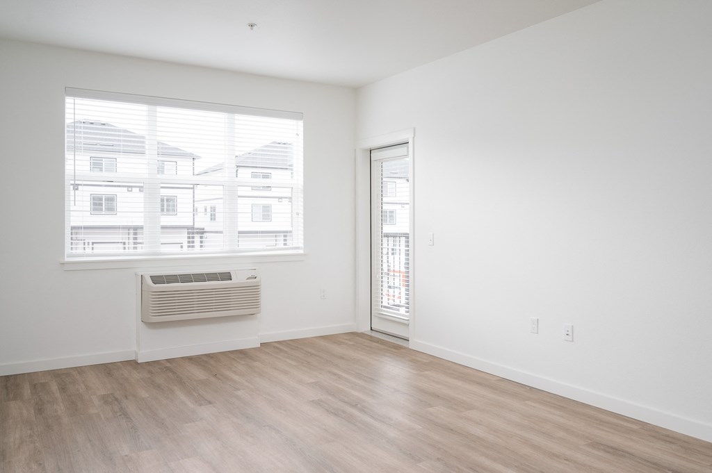A room with a window showing a view of houses outside.