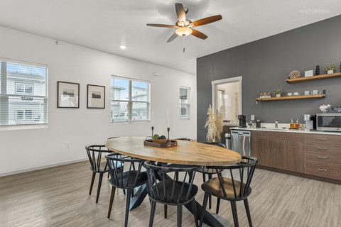 A modern dining room with a round wooden table and chairs.