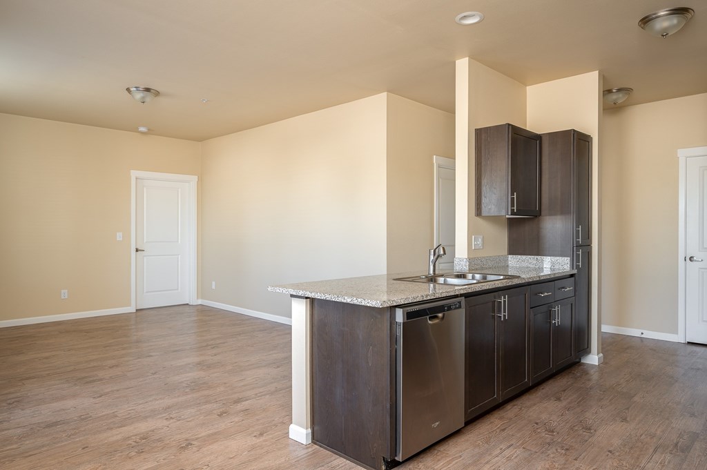 A kitchen with a sink, stove, and cabinets.