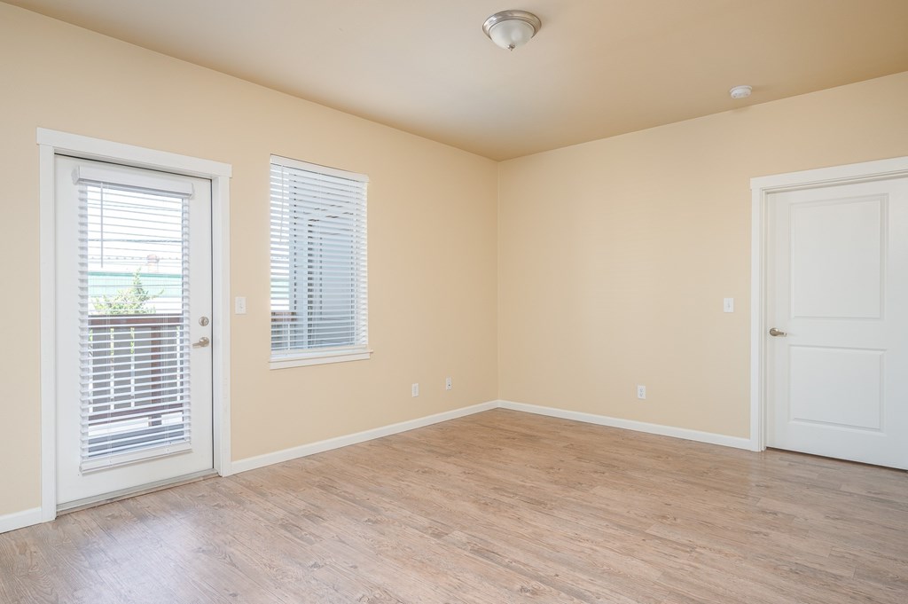 A room with wooden flooring and two white doors.