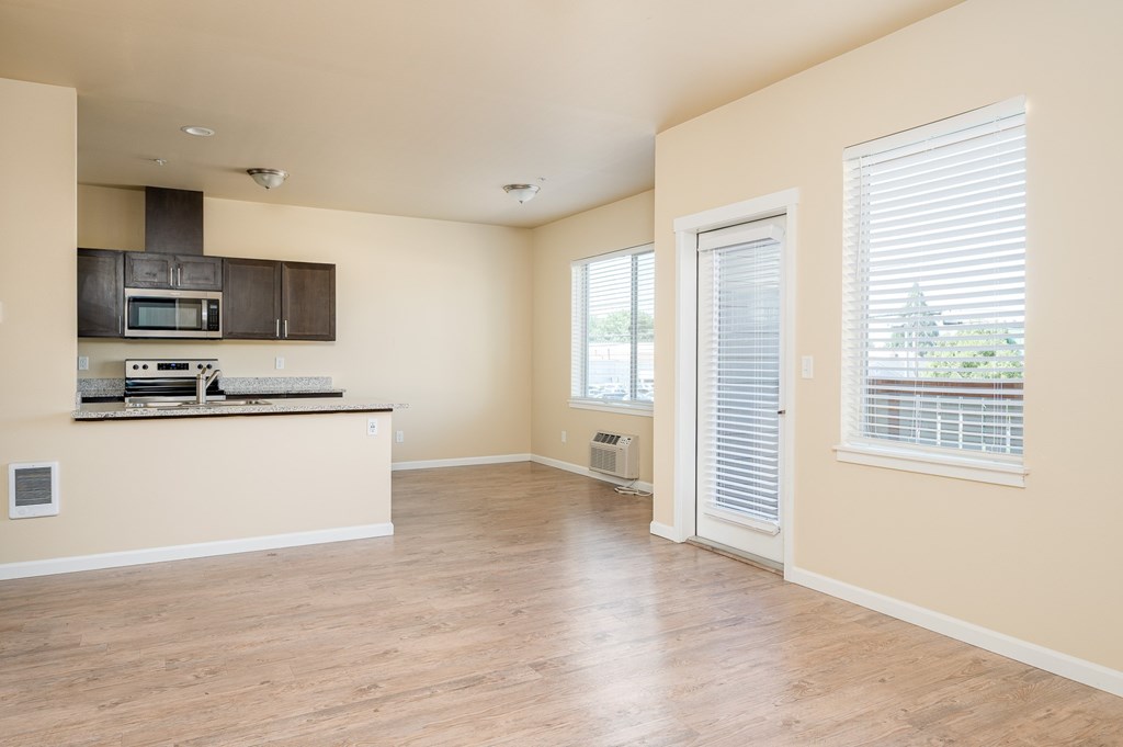 A kitchen with a microwave, oven, and stove top.