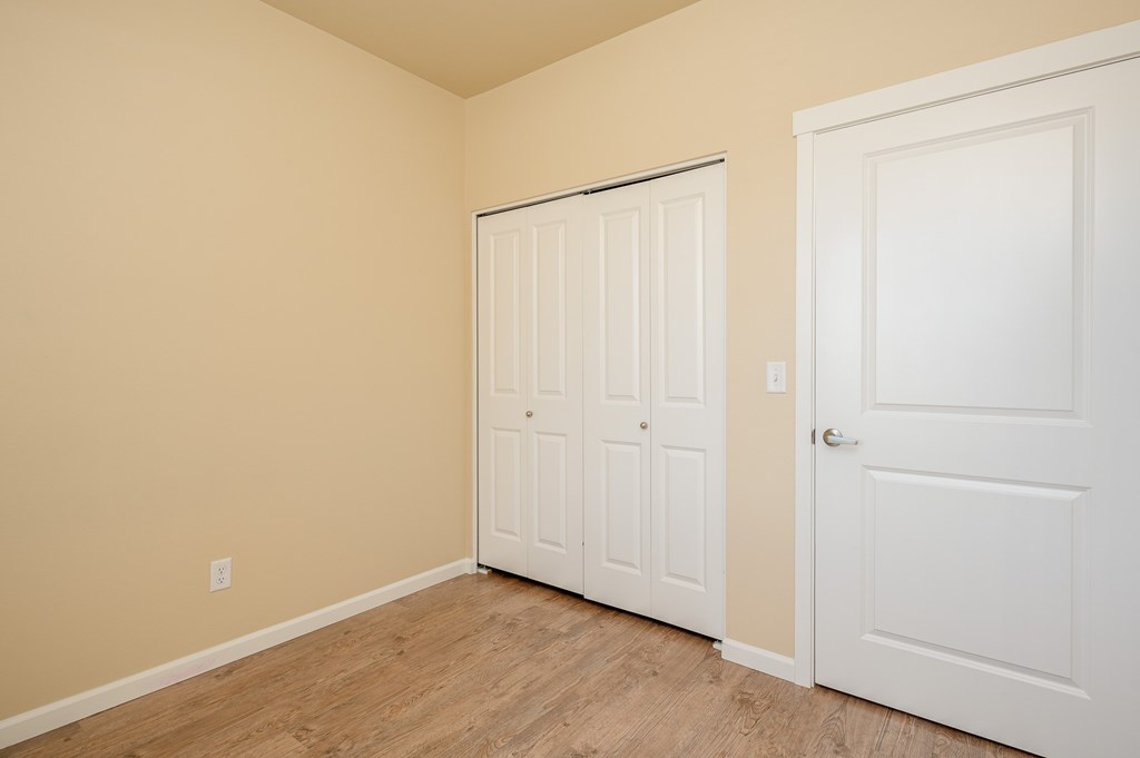 A room with a white door and a white closet door.
